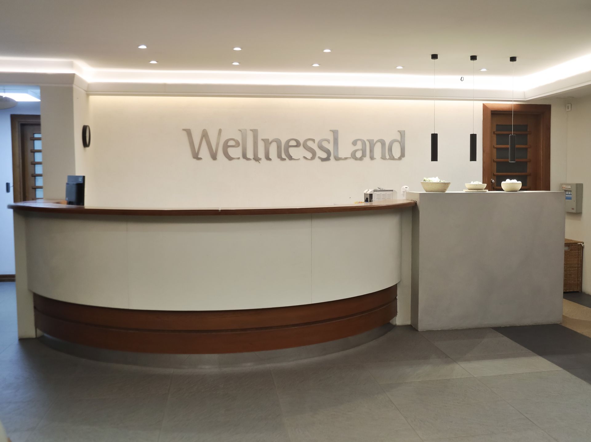 a wellnessland sign is above a reception desk
