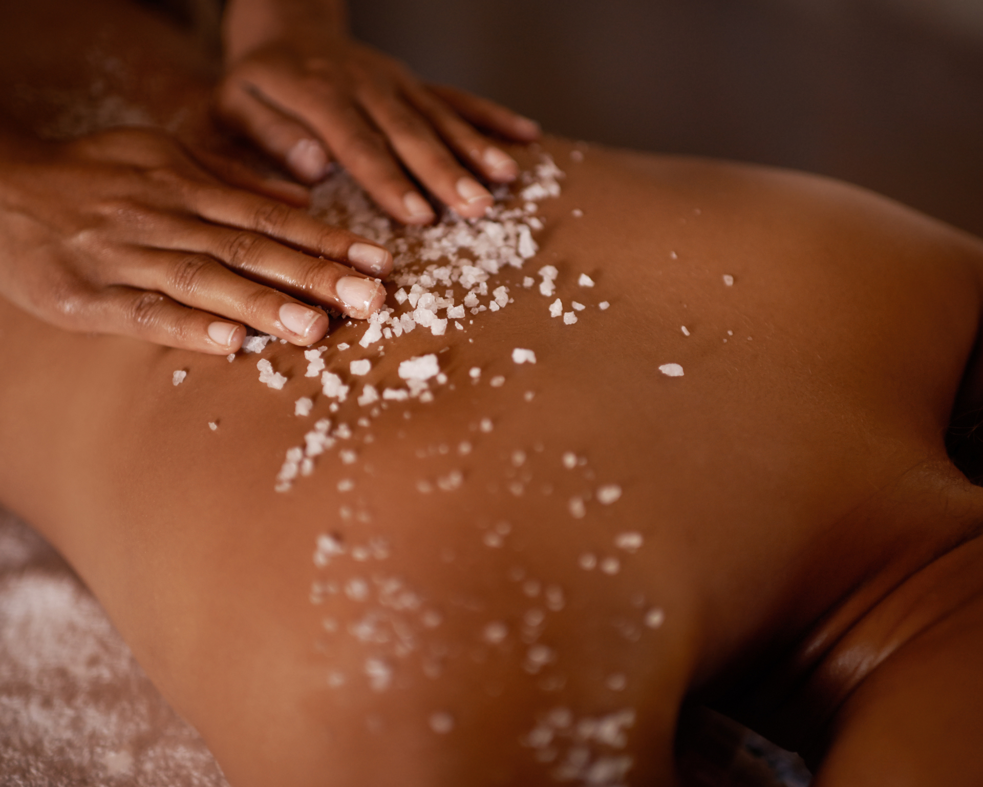 a woman is getting a massage with sea salt on her back