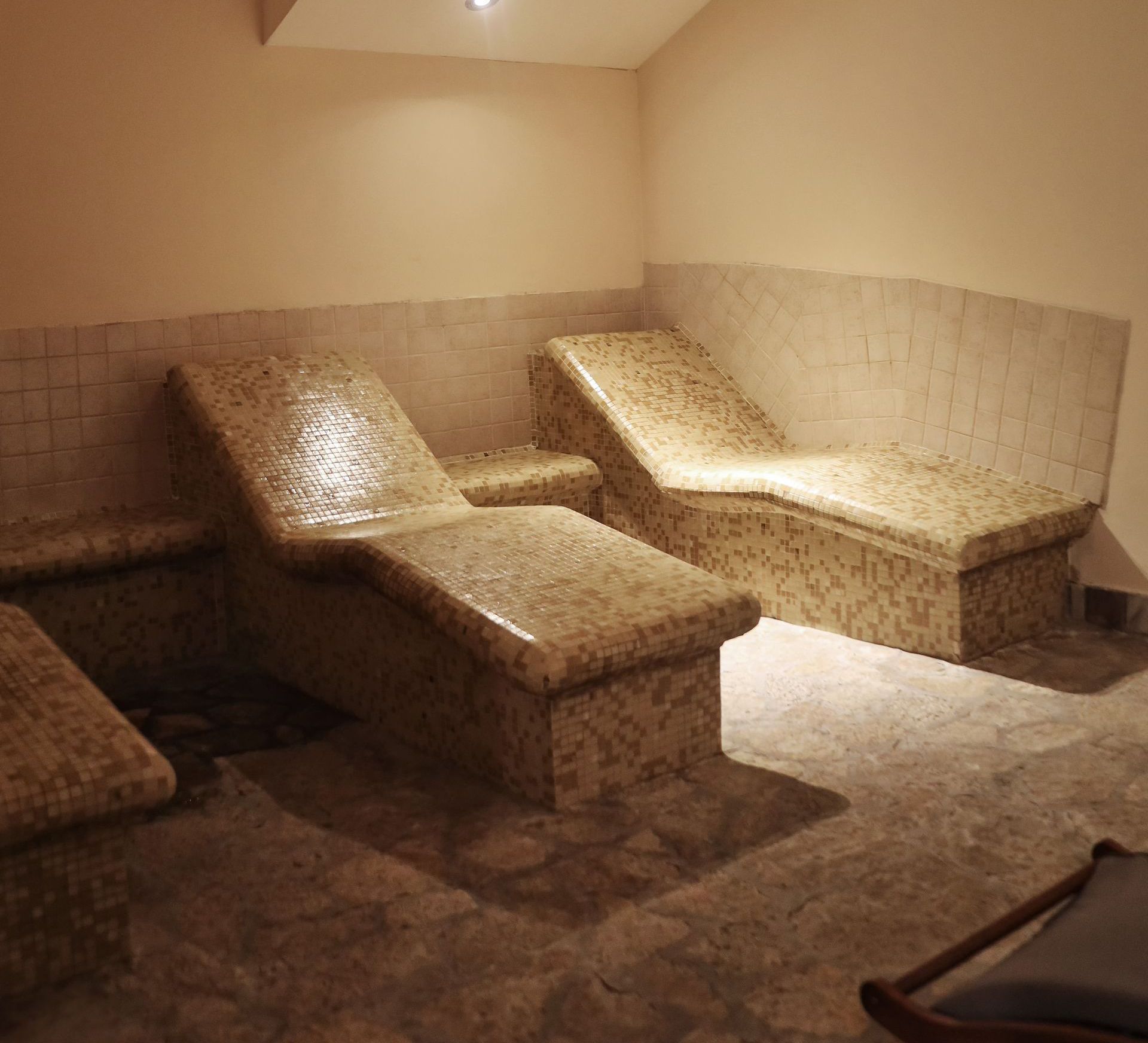 two lounge chairs in a room with tiled walls