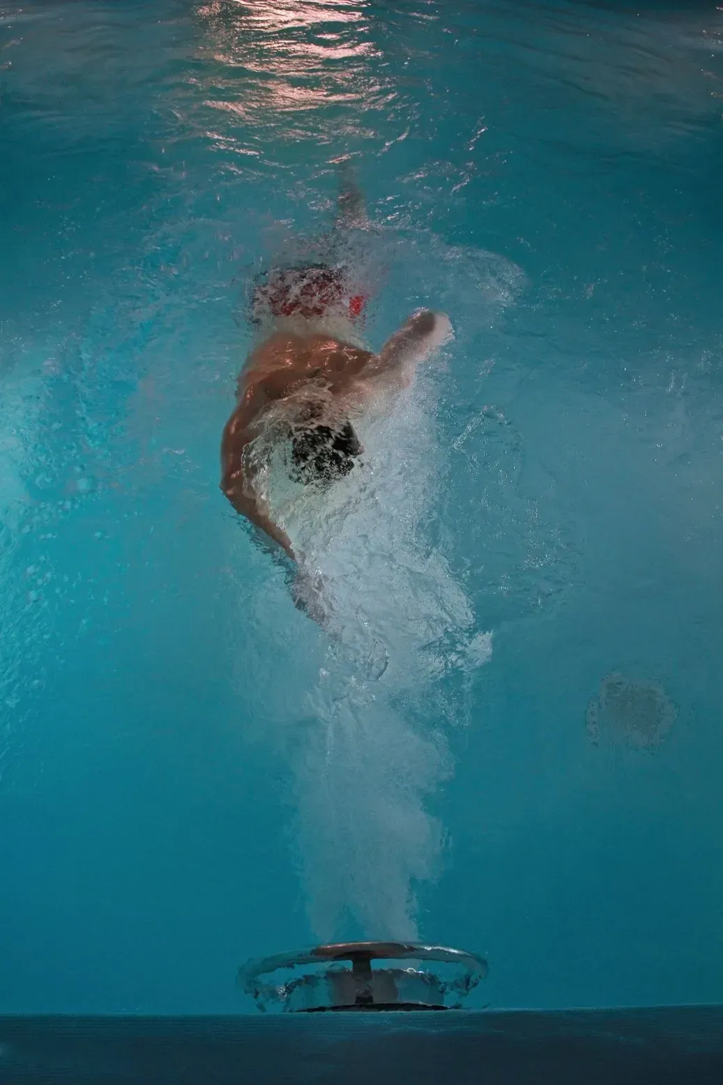 a person is jumping into a swimming pool .