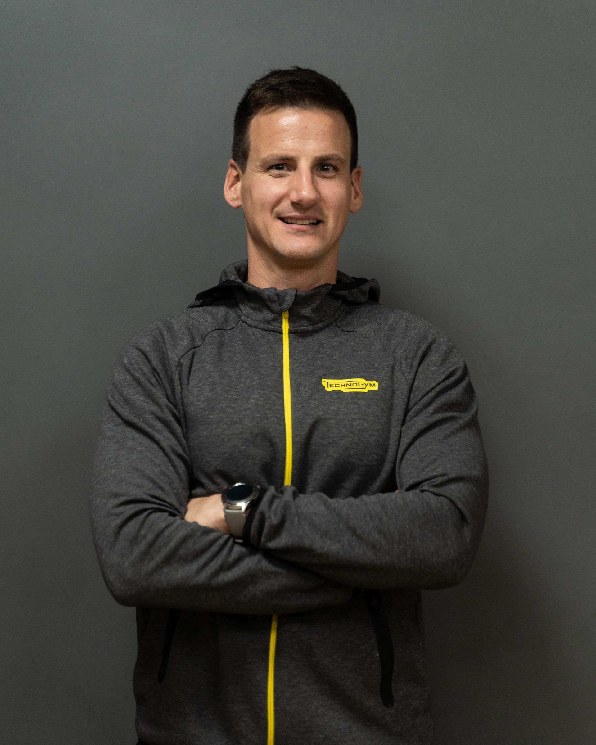 a man wearing a grey jacket with the word technogym on it