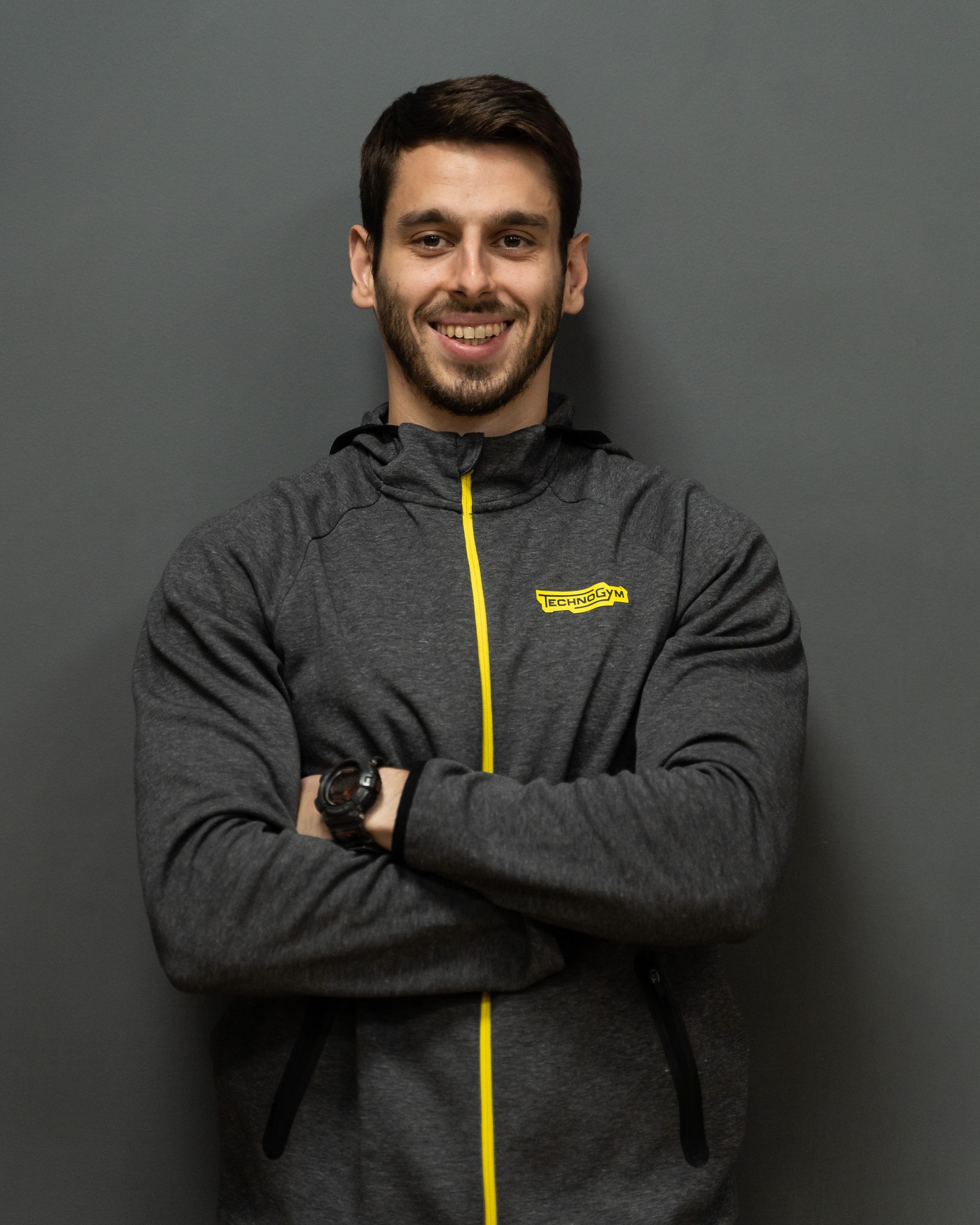 a man wearing a grey jacket with the word technogym on it