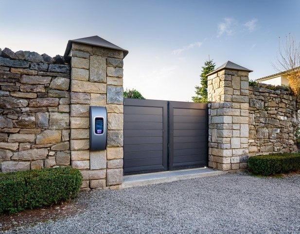 Stone wall and gate with an electric vehicle charger.
