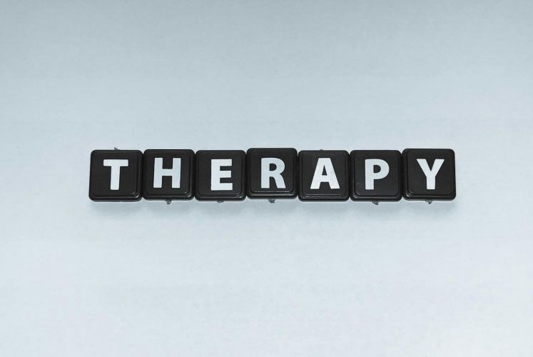 The word therapy is written in black keys on a white background.