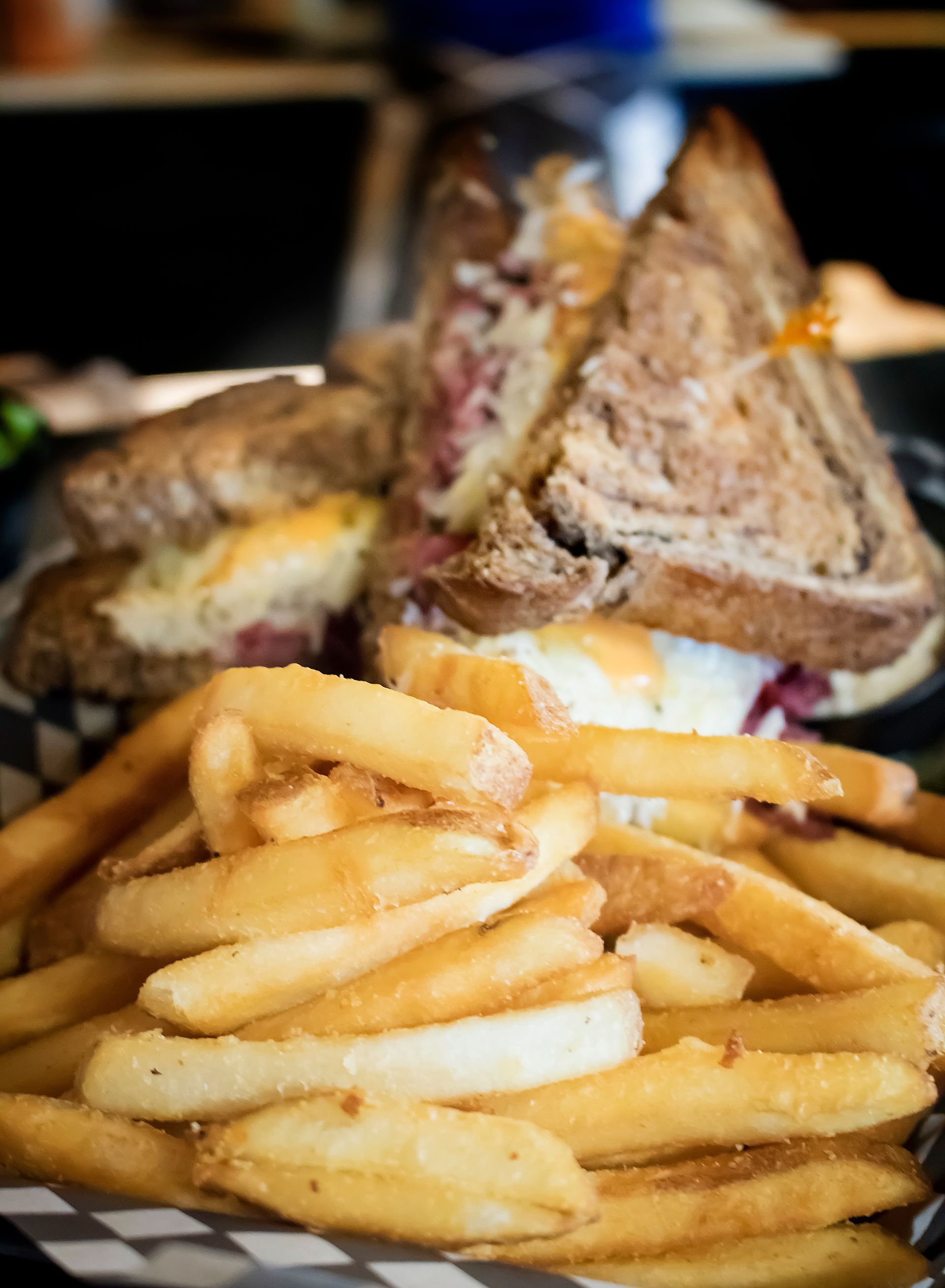 A close up of a sandwich and french fries on a table.