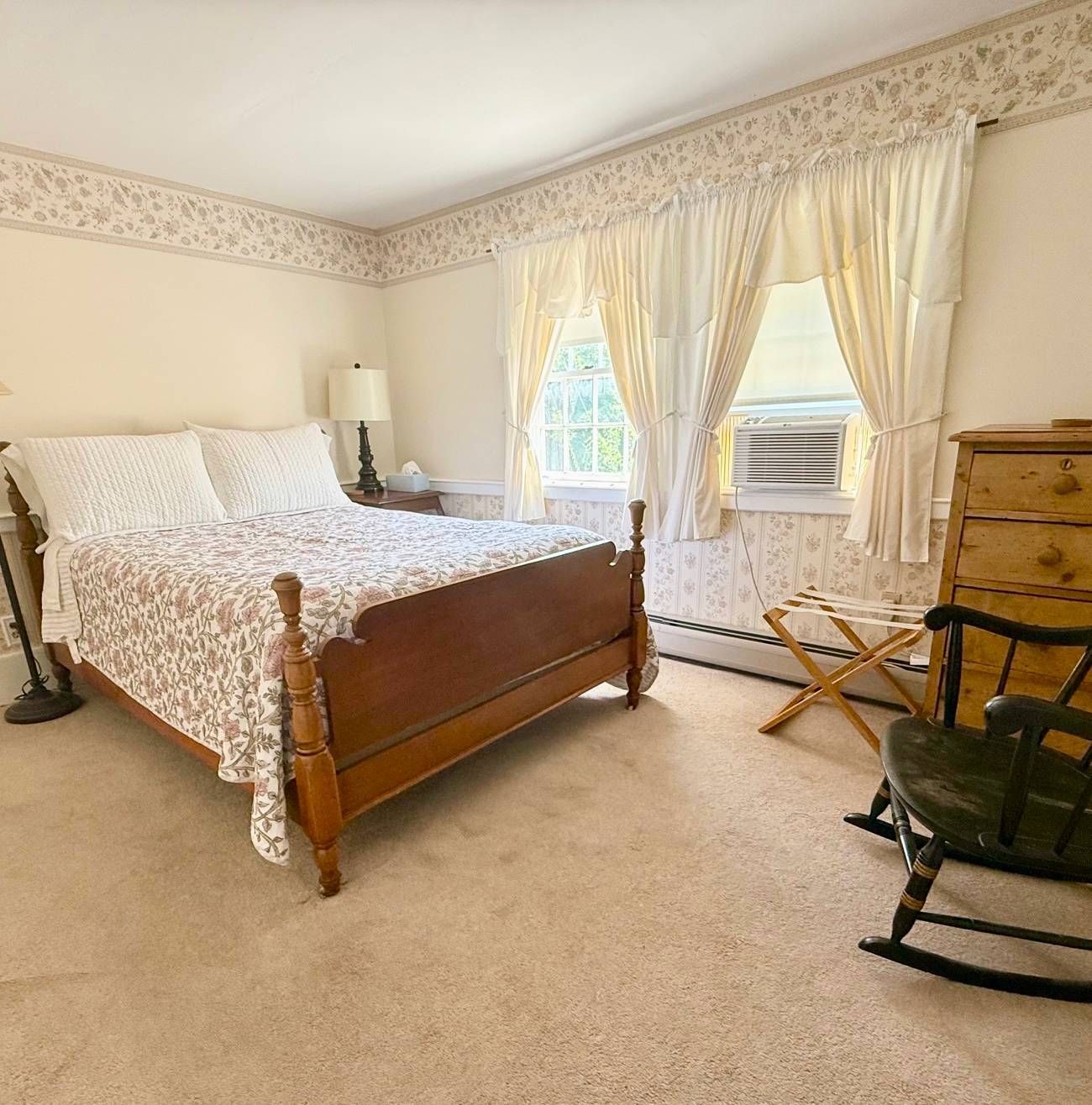 A bedroom with a bed and a rocking chair