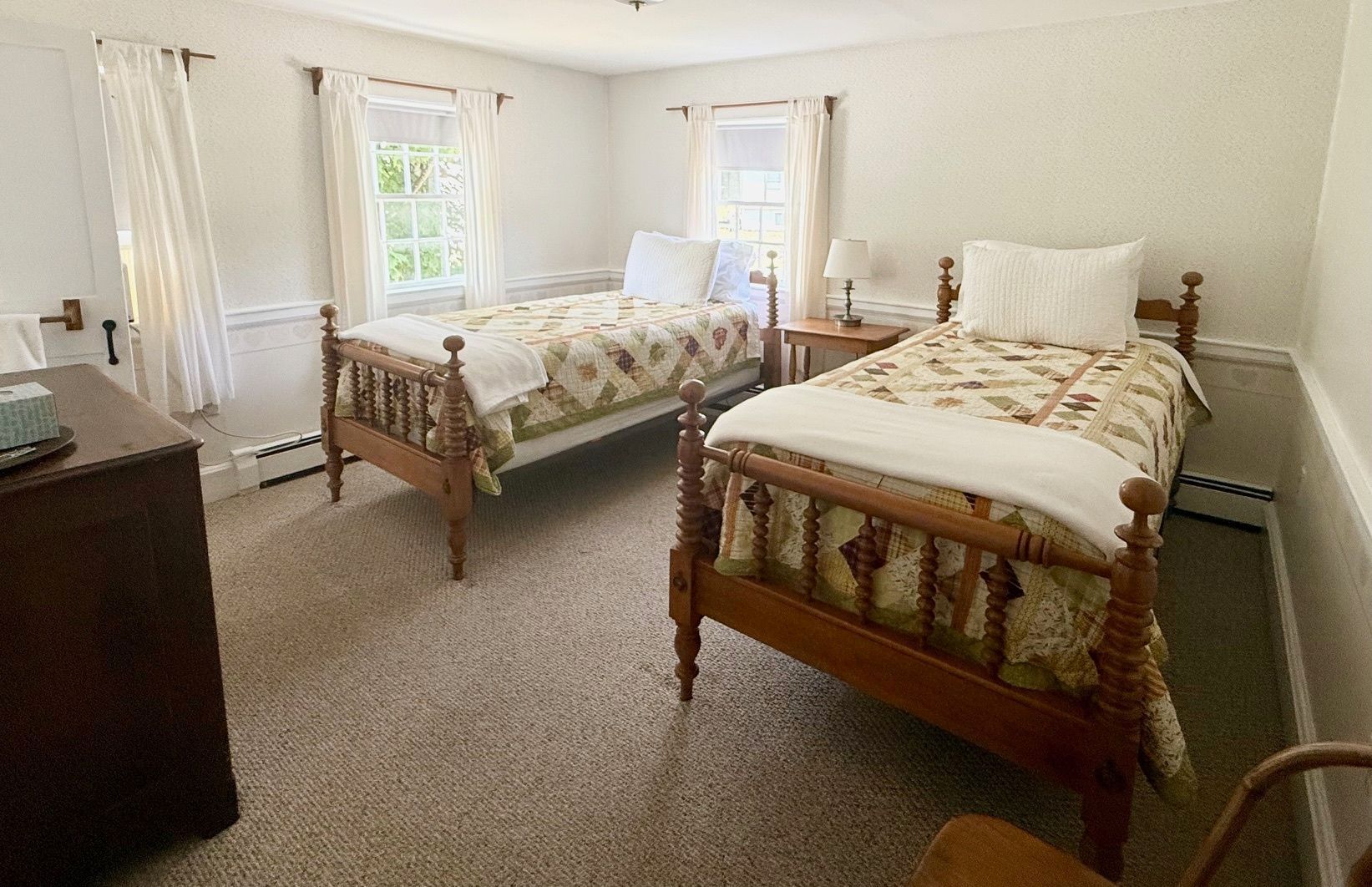A bedroom with two twin beds and a dresser.