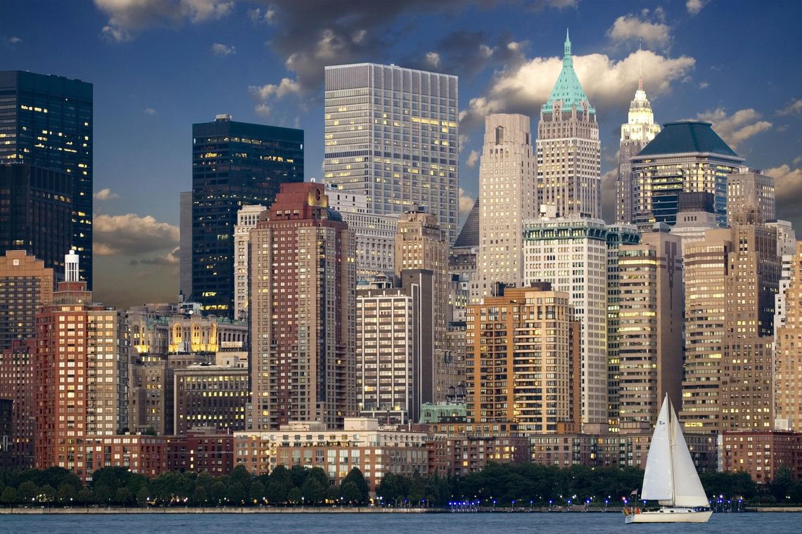 A city skyline with a sailboat in the foreground
