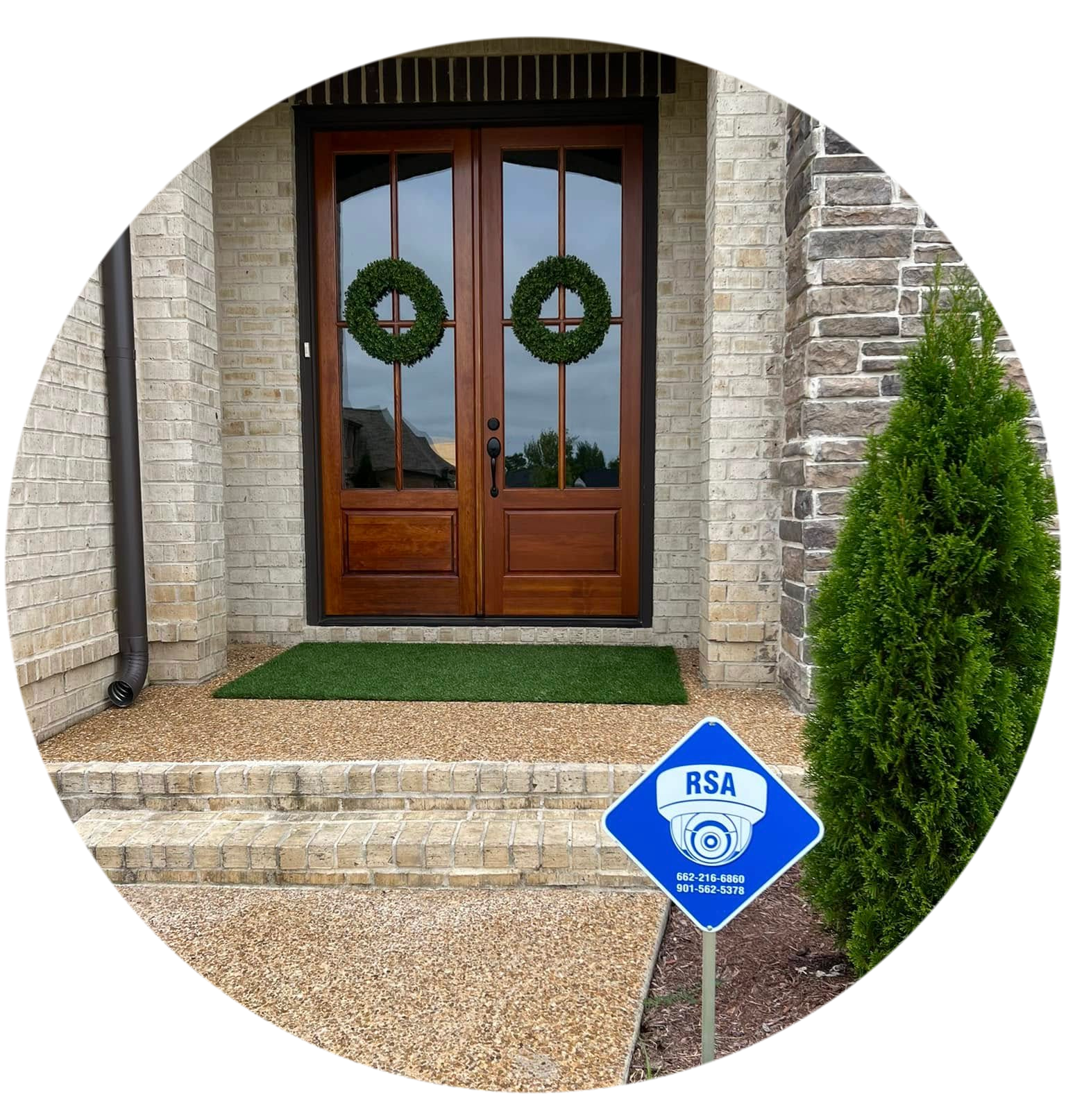 a view of front doors and blue security sign placed out front