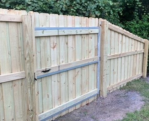 Wooden fence with a gate, light-colored wood, outdoors.