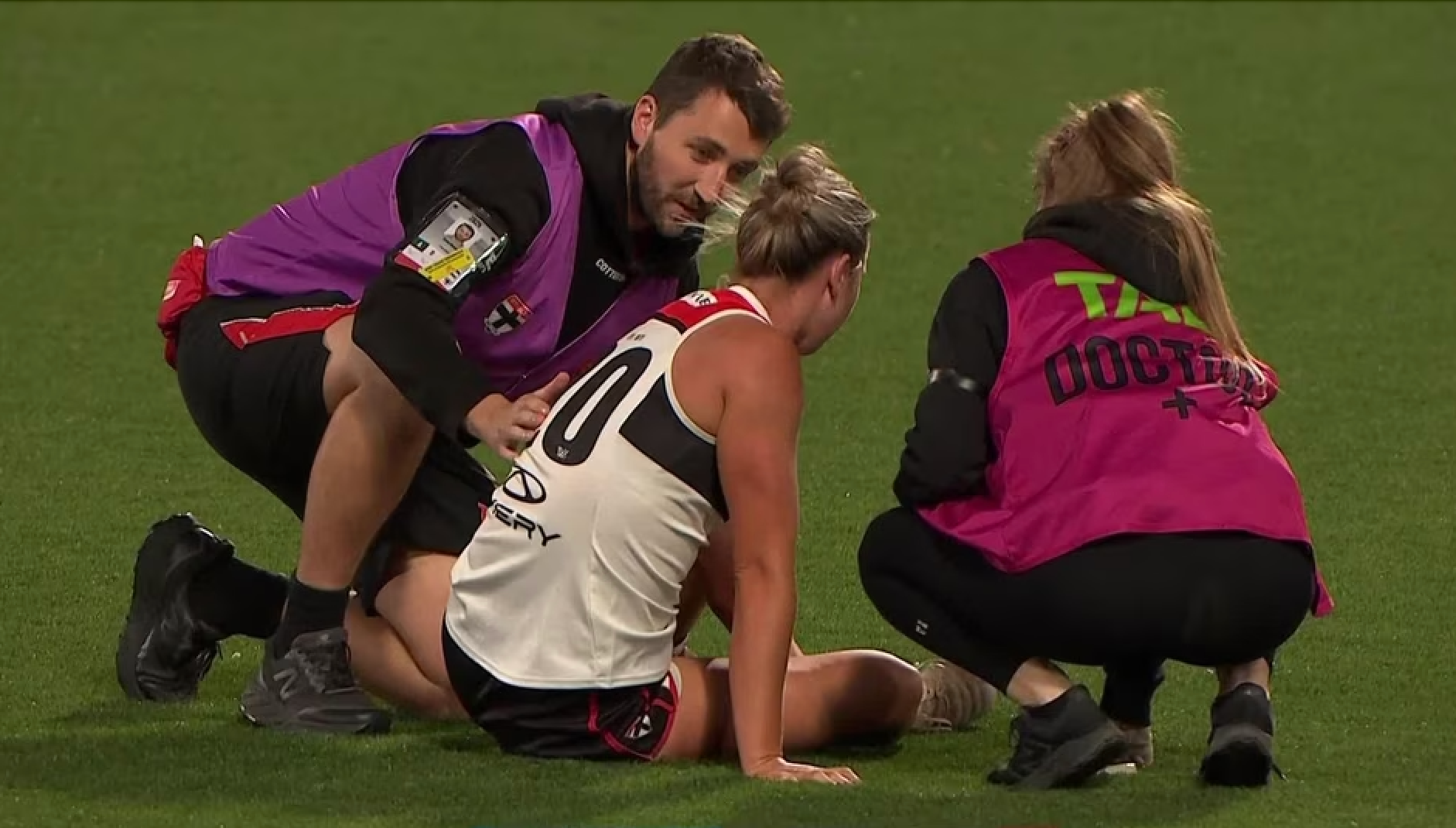 St Kilda AFLW Player Injured, supported by medical staff, on ground assessment