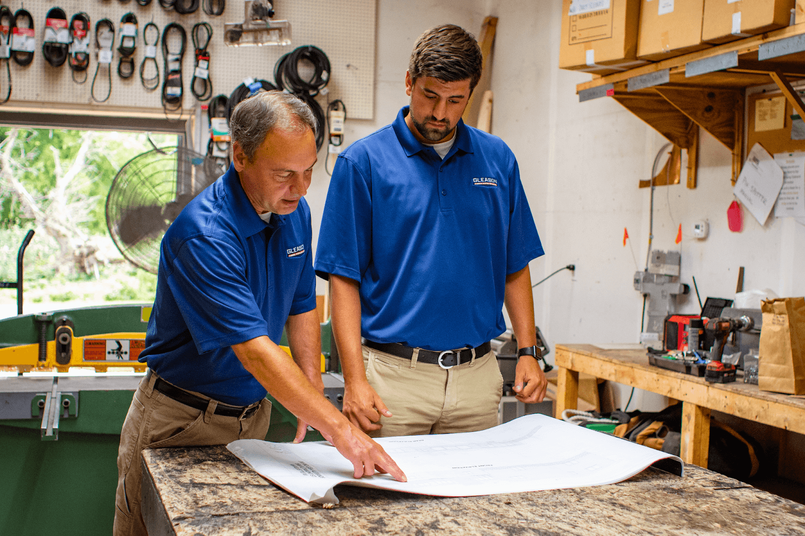 Two men are looking at a blueprint to do Sump Pump Installation