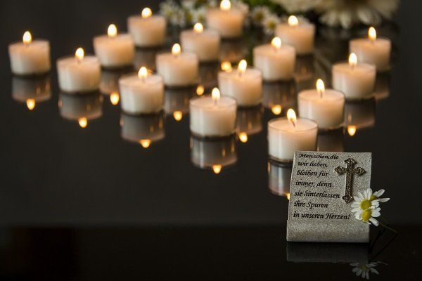 candele accese e placca funebre in marmo