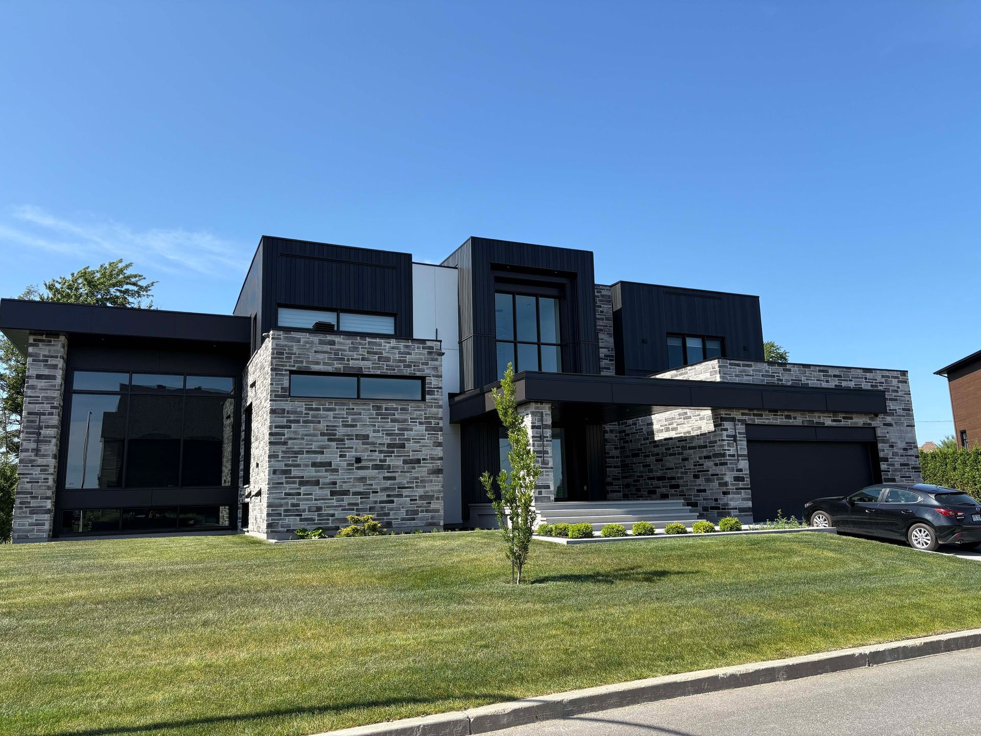 Une grande maison avec une voiture garée devant.