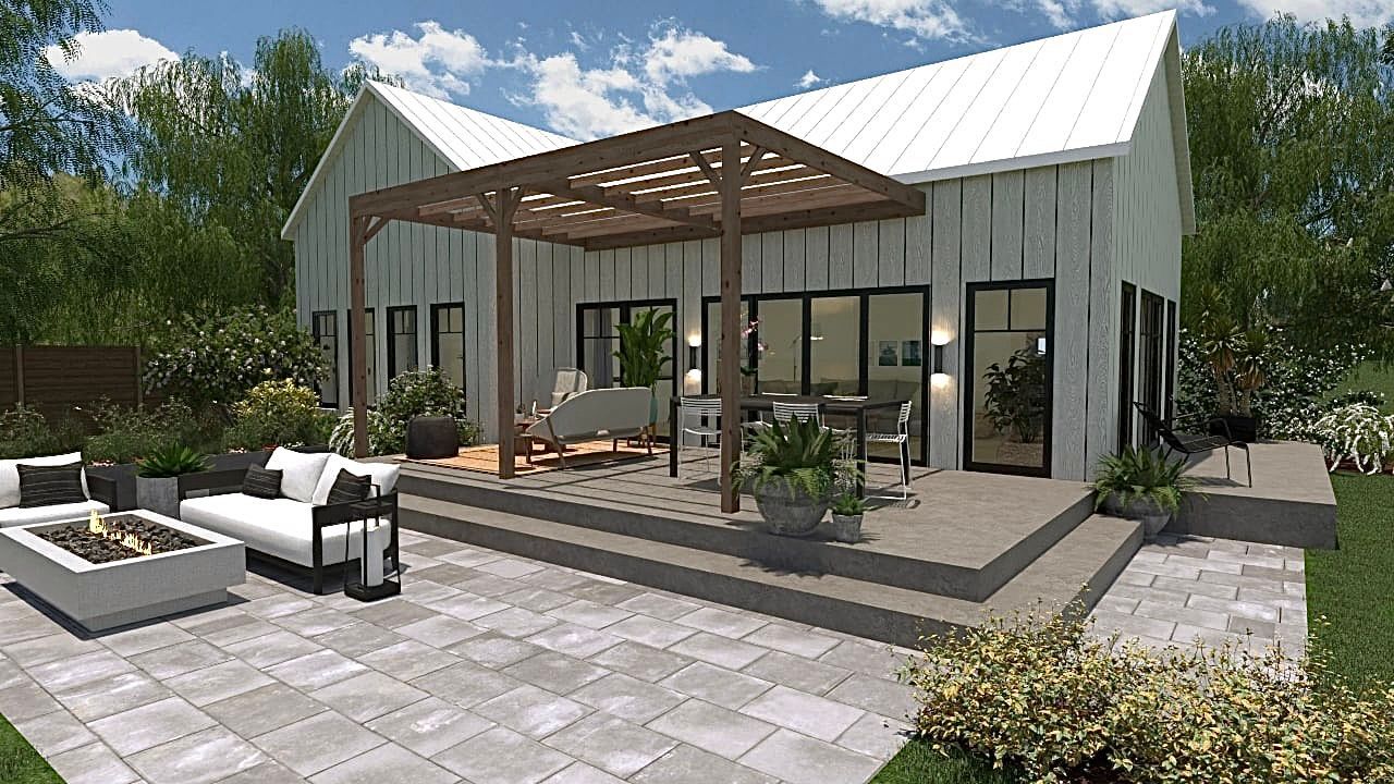 Une maison blanche avec un patio et un foyer devant.