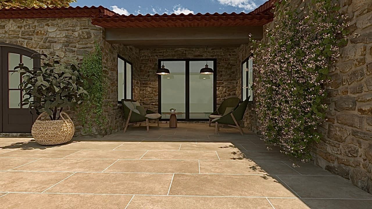 Un bâtiment en pierre avec un patio et des chaises devant.