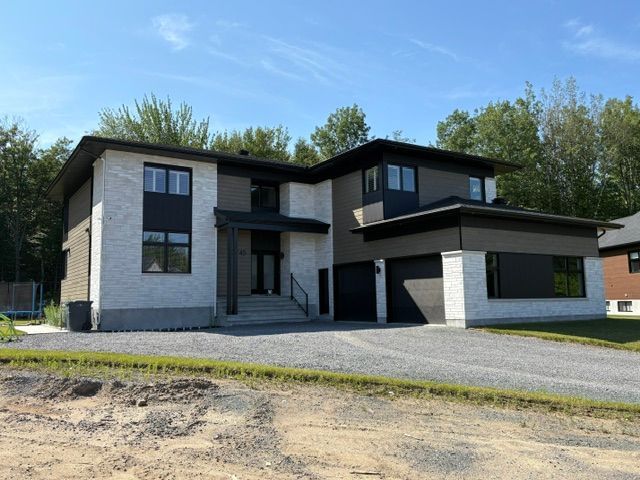 Une grande maison avec beaucoup de fenêtres et une allée