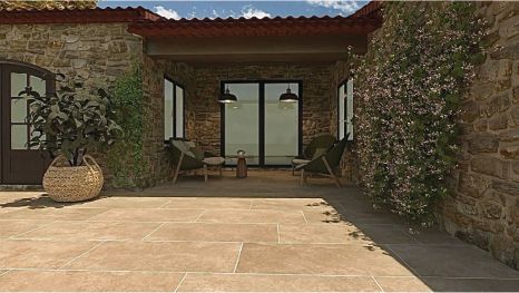 Un bâtiment en pierre avec un patio et des chaises devant.