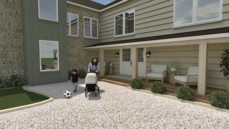 Une femme pousse une poussette devant une grande maison.