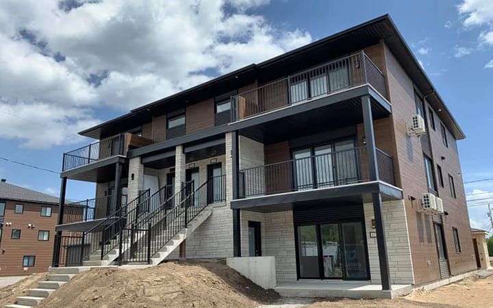 Un grand immeuble d'appartements avec beaucoup de fenêtres et de balcons.