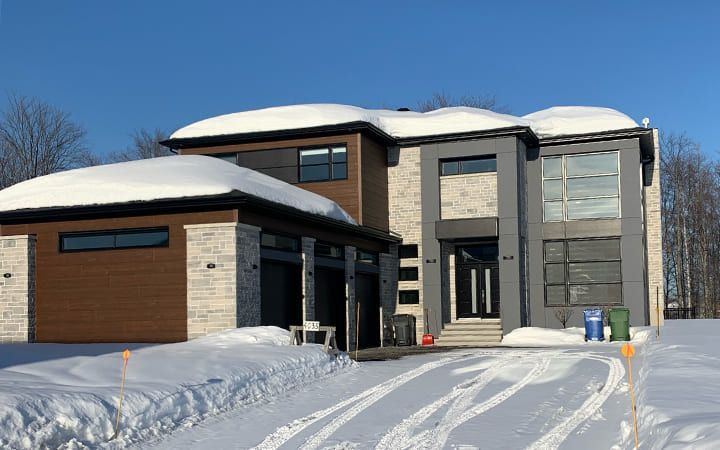Une grande maison est située au milieu d'un champ enneigé.