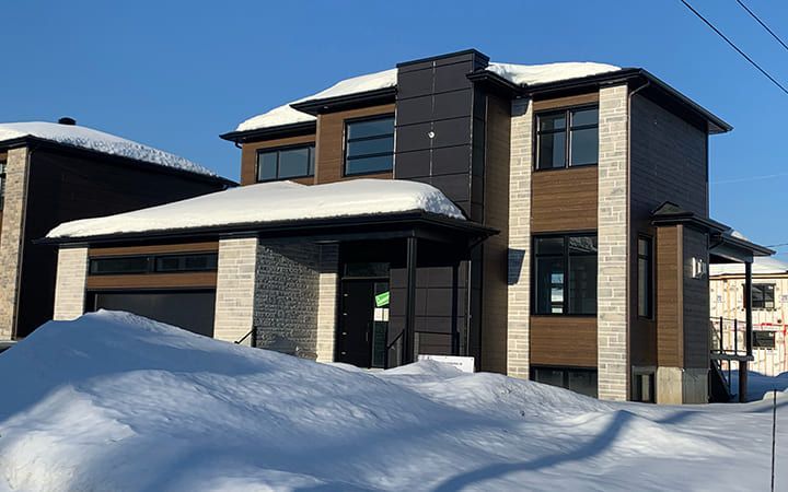 Une maison avec beaucoup de neige sur le sol devant elle