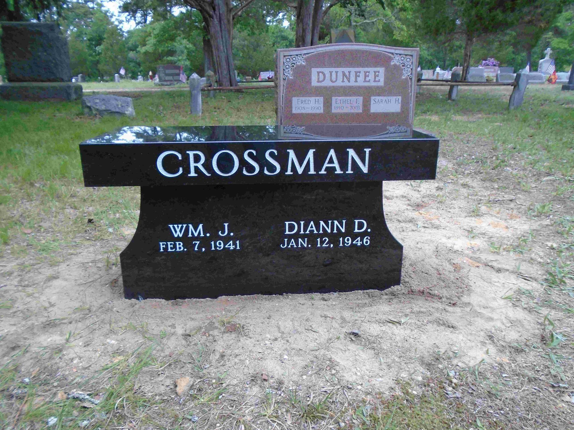 A black bench with the name crossman on it