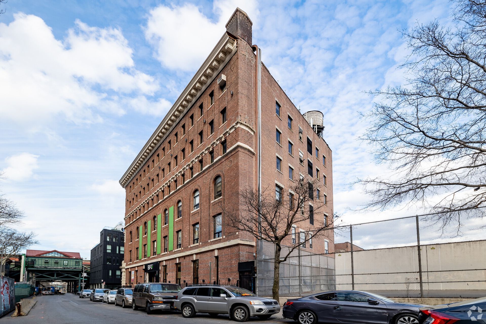 A large brick building with cars parked in front of it.