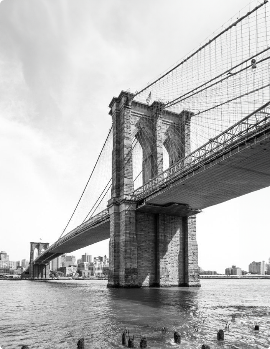 A black and white photo of the Brooklyn bridge over a body of water.