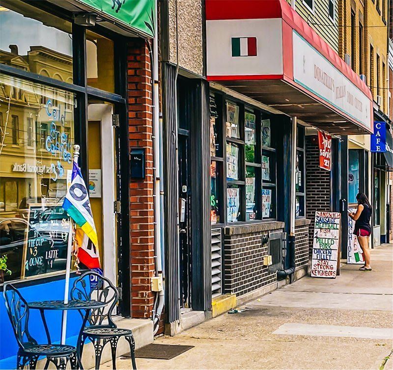 a store front with a red awning and a flag on it