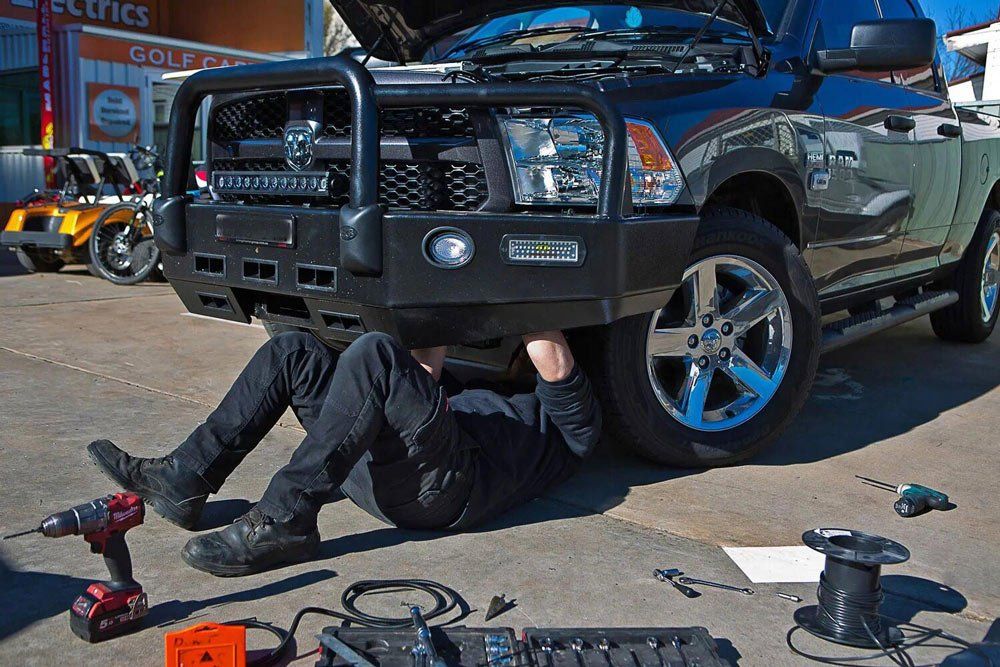 Auto Electrician Working Under The Vehicle — Golf Carts and Auto Electrical Services in Orange