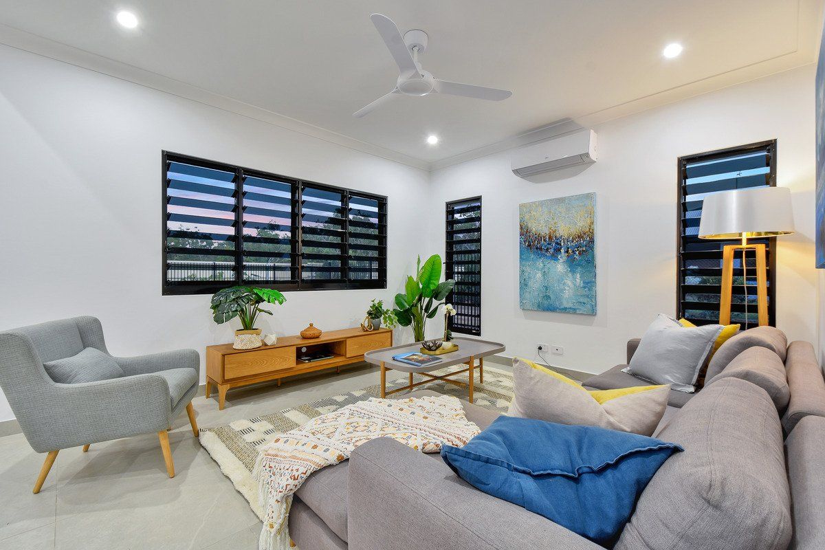 Cozy living room with gray sofa, wooden furniture, and large windows.