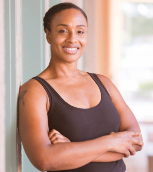 A woman leaning against a wall with her arms crossed