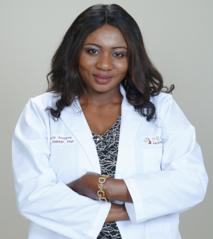 A woman in a white lab coat has her arms crossed