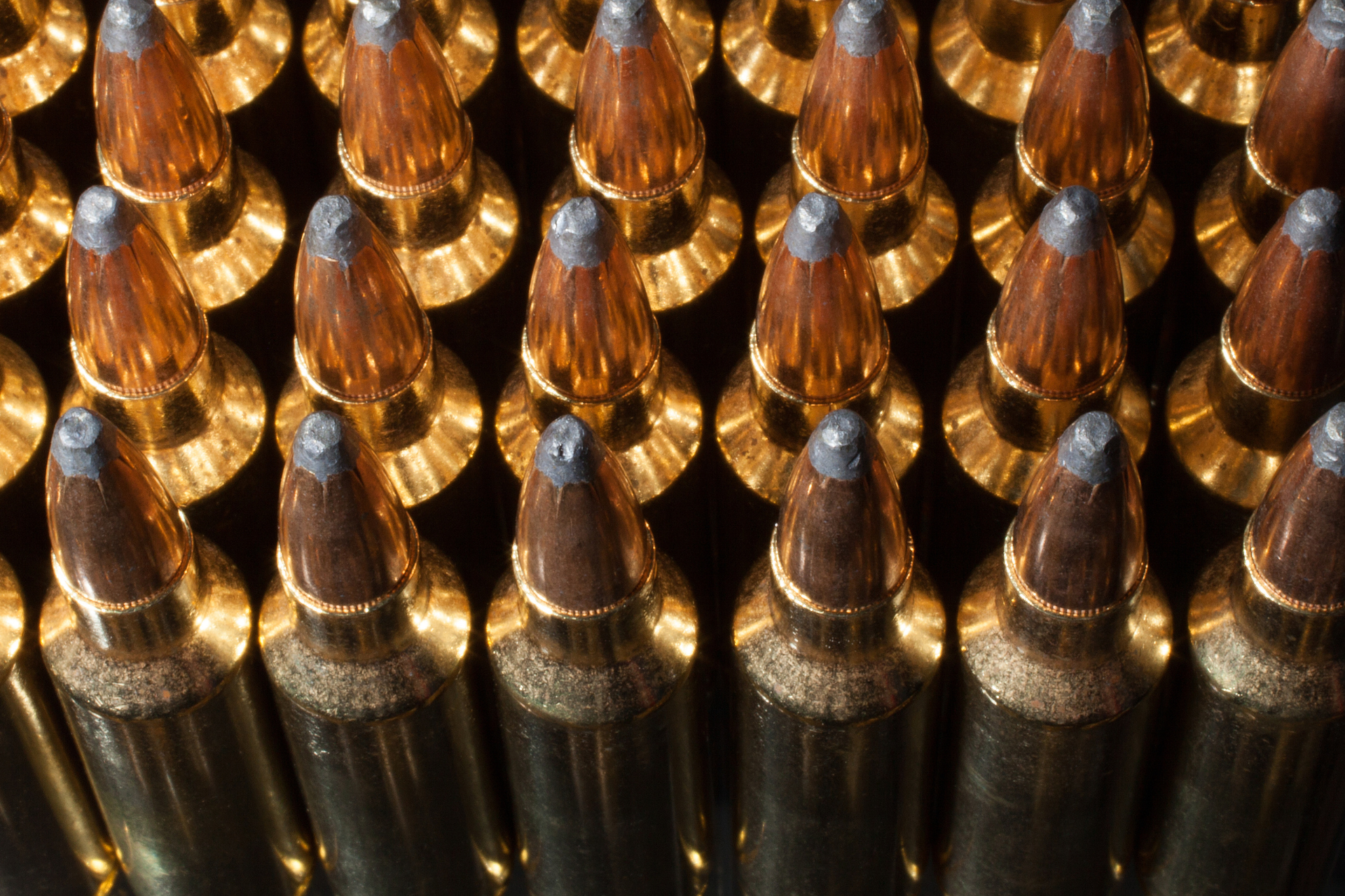 A bunch of bullets are lined up in a row on a table.