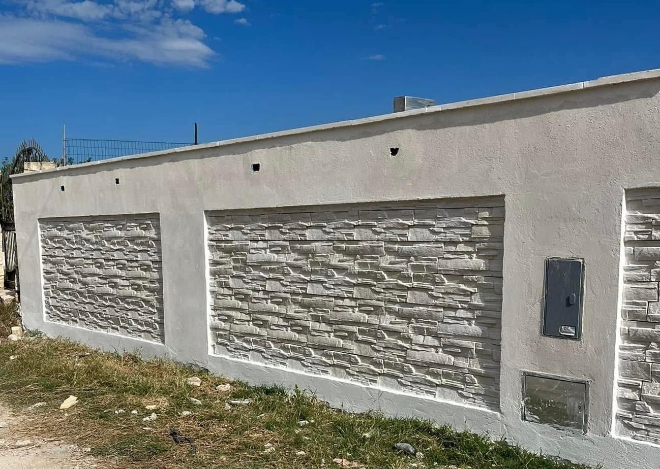 Un muro di mattoni bianchi con un cielo azzurro sullo sfondo