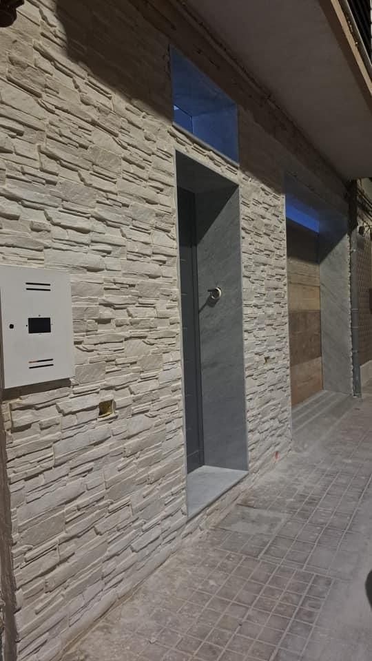 Un edificio in mattoni con una porta e una cassetta postale sul marciapiede.