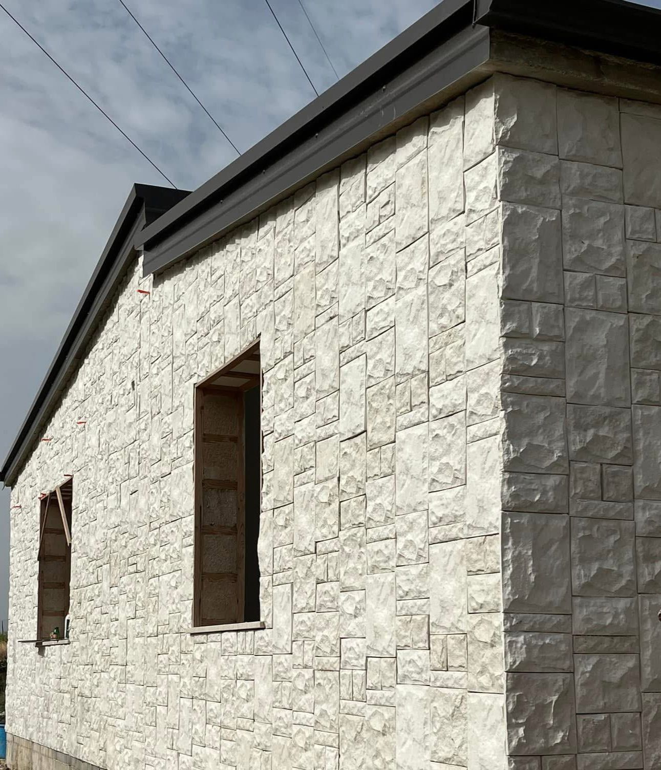 Un edificio in mattoni bianchi con un tetto nero