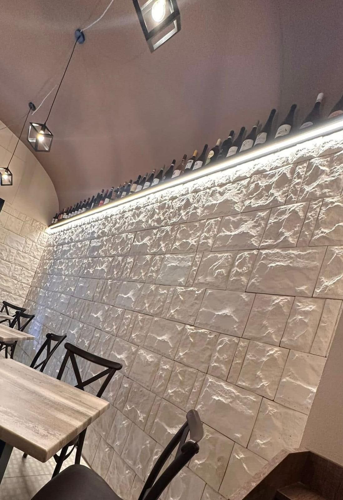 Un ristorante con tavoli e sedie e un muro di mattoni.