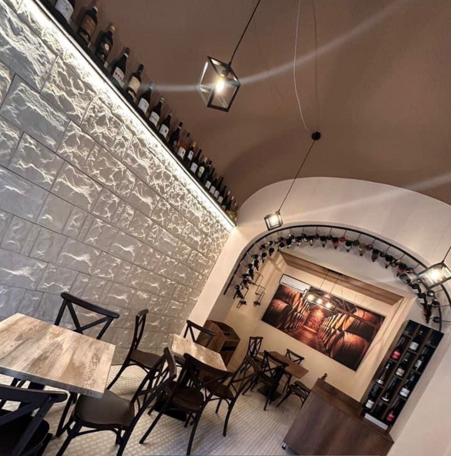 Un ristorante con tavoli e sedie e bottiglie sul muro