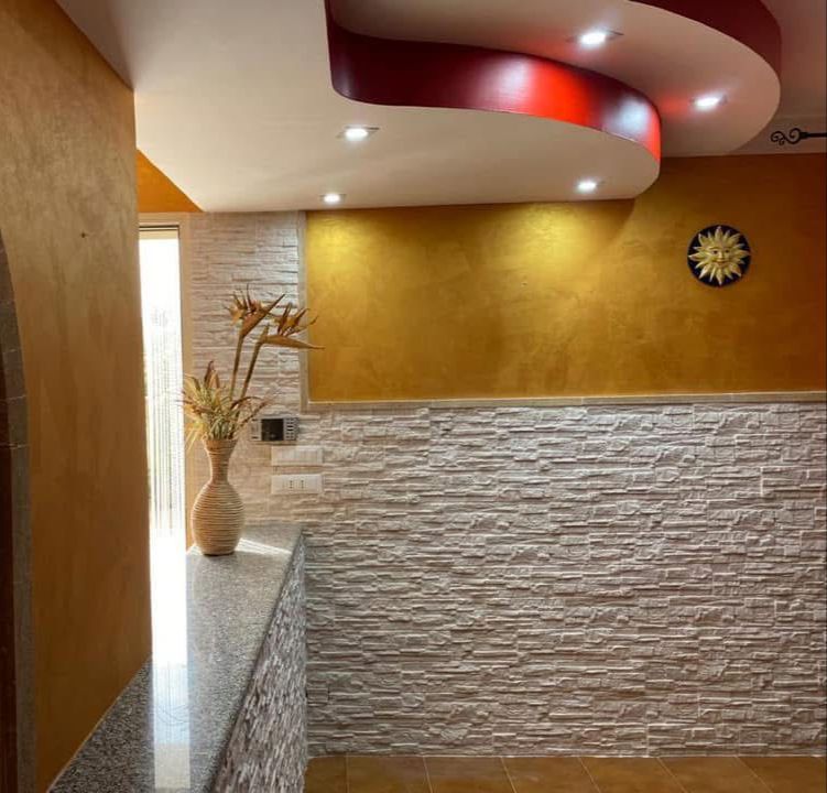 Una stanza con un muro di mattoni e un orologio sul muro