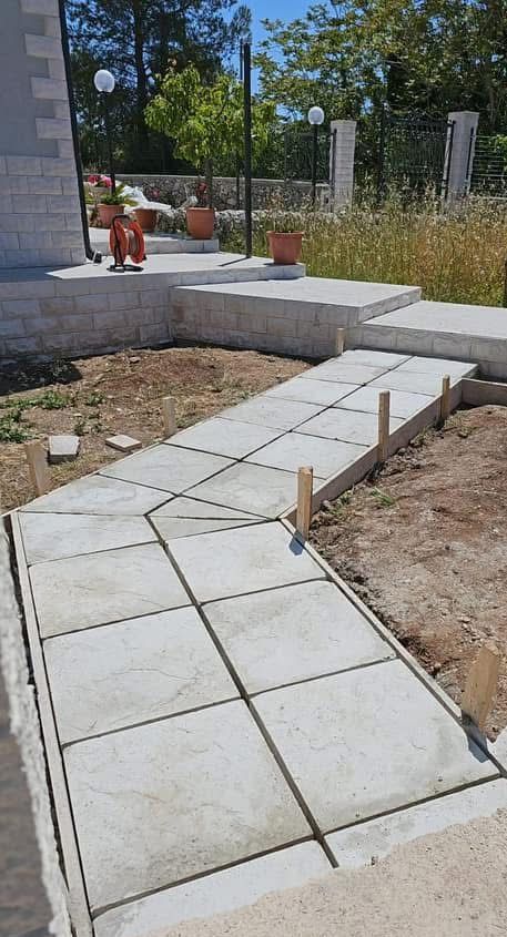 In un cortile viene costruita una passerella in cemento.