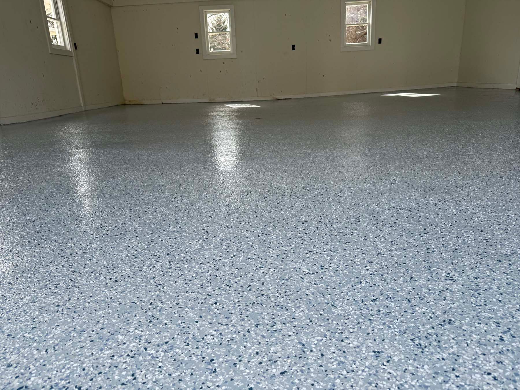 A garage with a gray concrete floor and white walls.