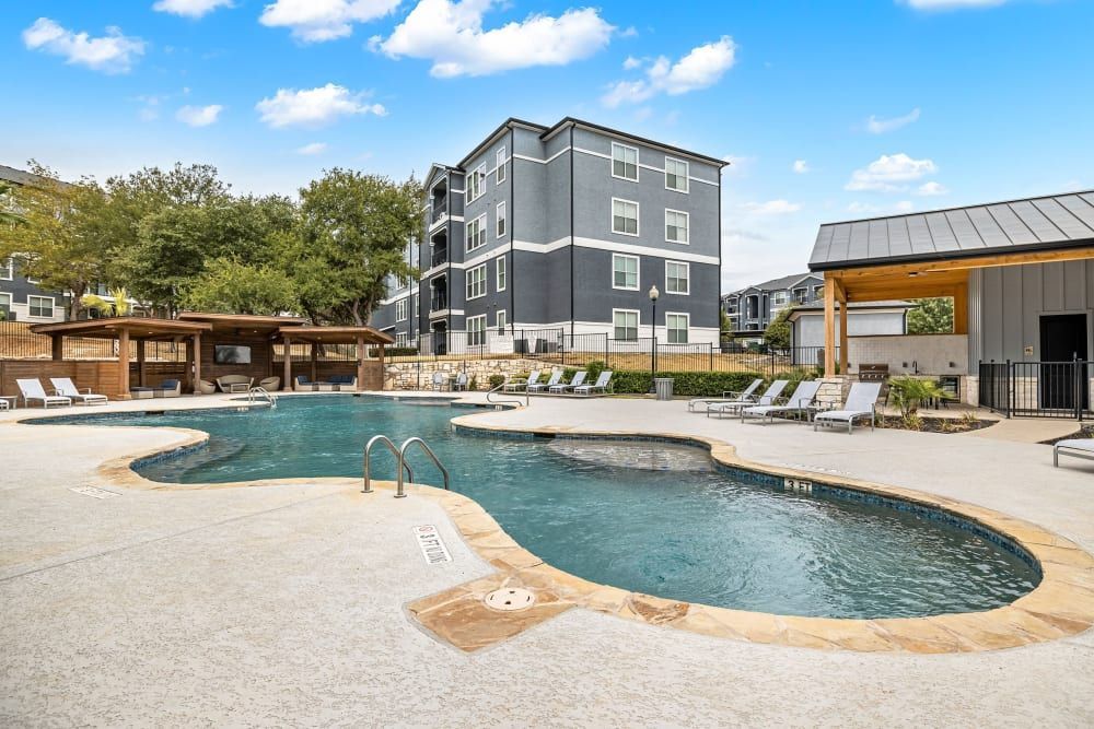 a large swimming pool with a building in the background at Marquis at Crown Ridge in San Antonio, TX.