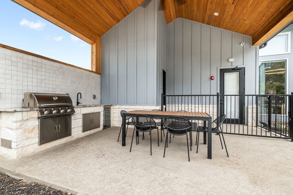a patio with a table and chairs and a grill at Marquis at Crown Ridge in San Antonio, TX.