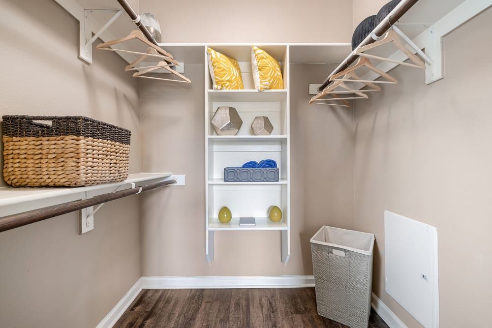 a walk-in closet with lots of shelves and a laundry basket at Marquis at Crown Ridge in San Antonio, TX.