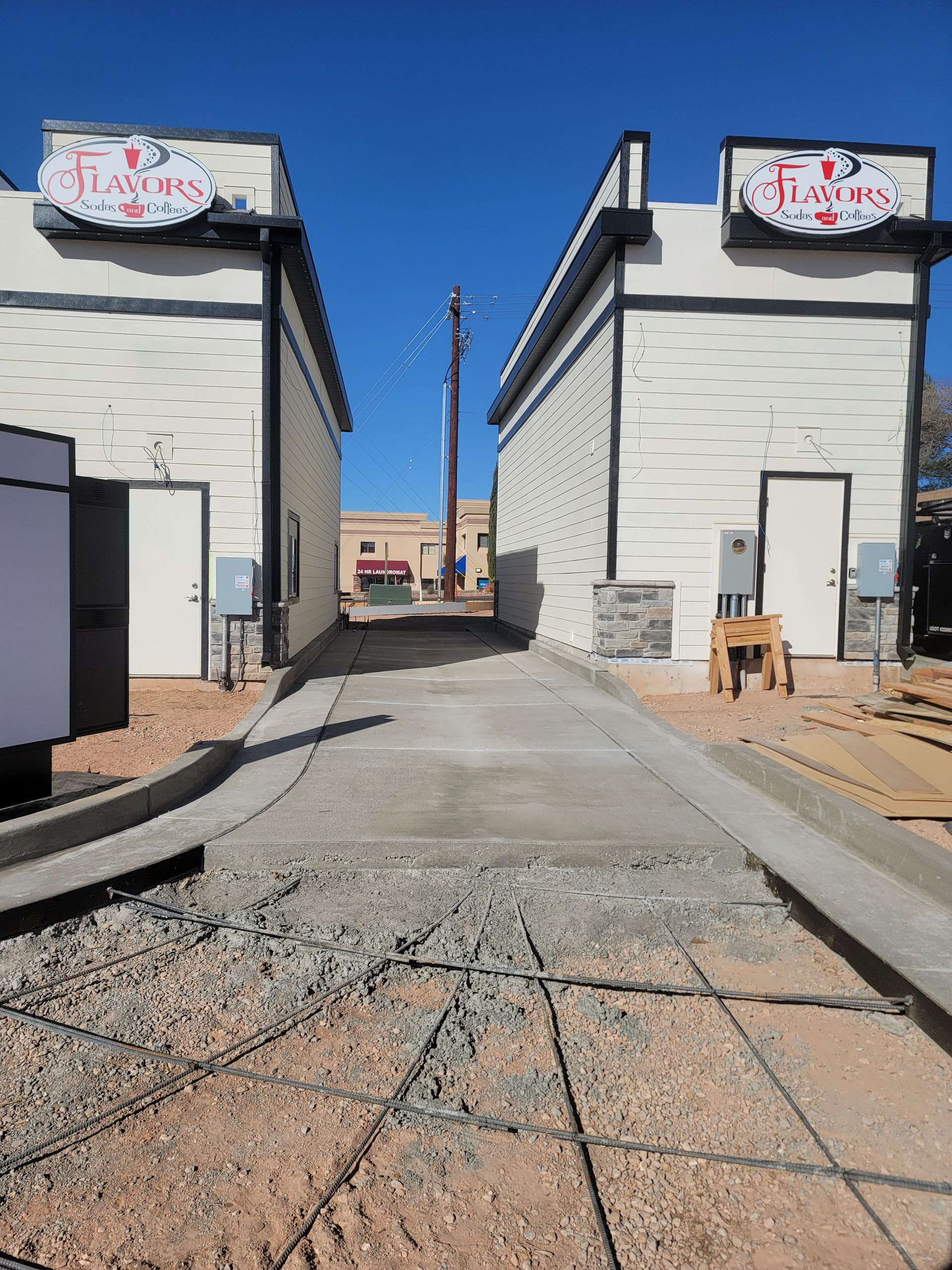 A concrete walkway between two buildings with a sign that says ' flying ' on it