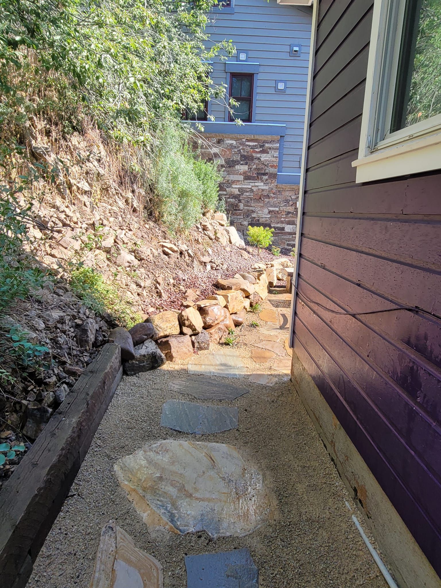 A purple house with a stone walkway leading to it.