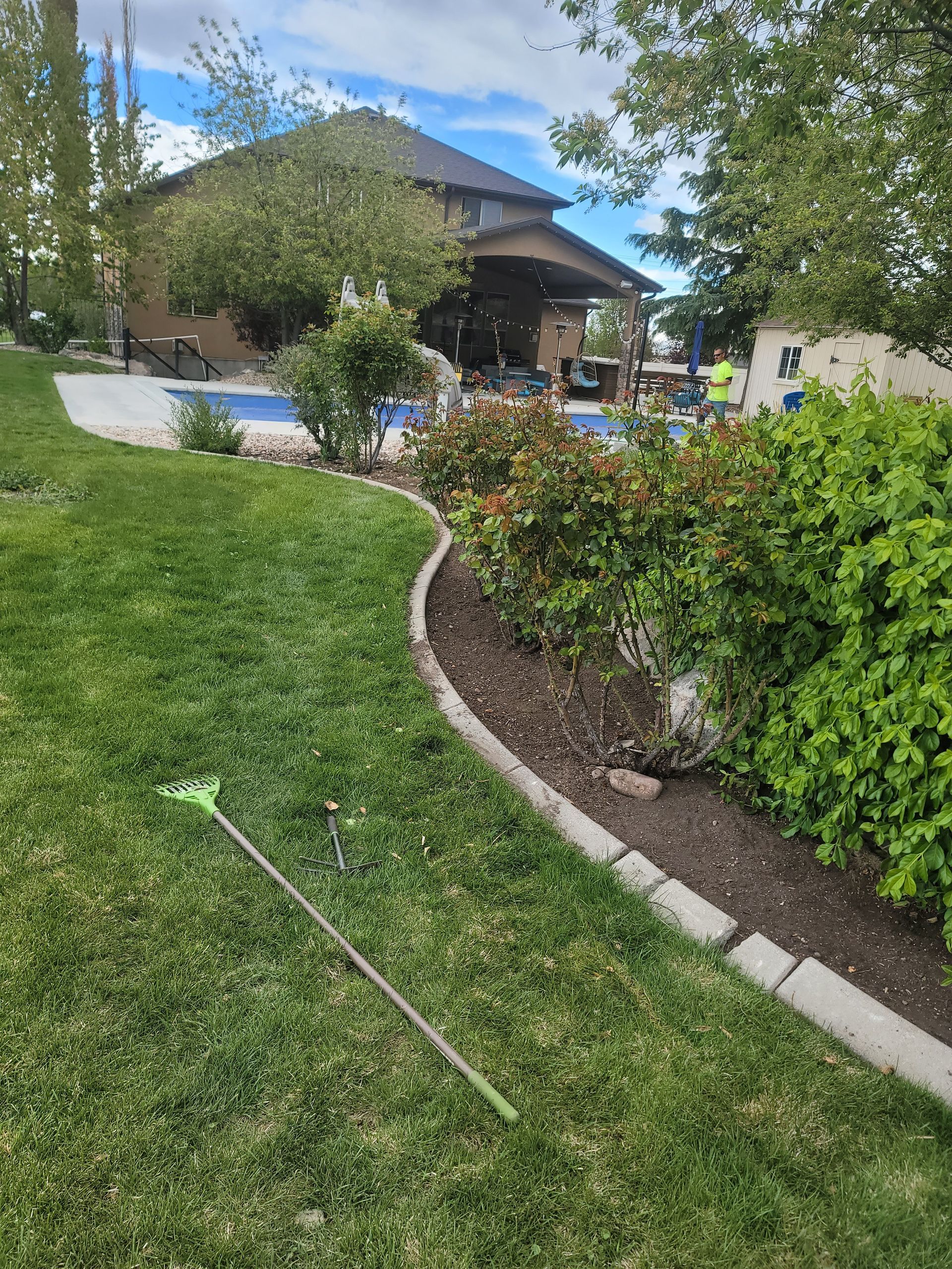 A lawn mower is sitting in the grass in front of a house.