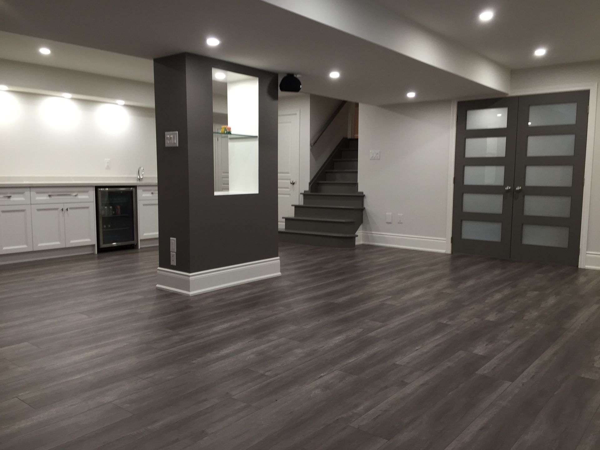 A white house with a brick driveway and a patio in front of it.